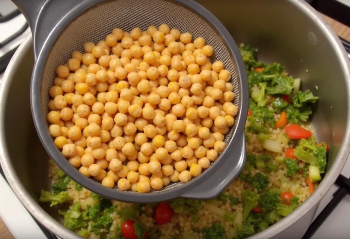 Grão-de-bico adicionado aos legumes refogados na sopa de grão com espinafres saudável.